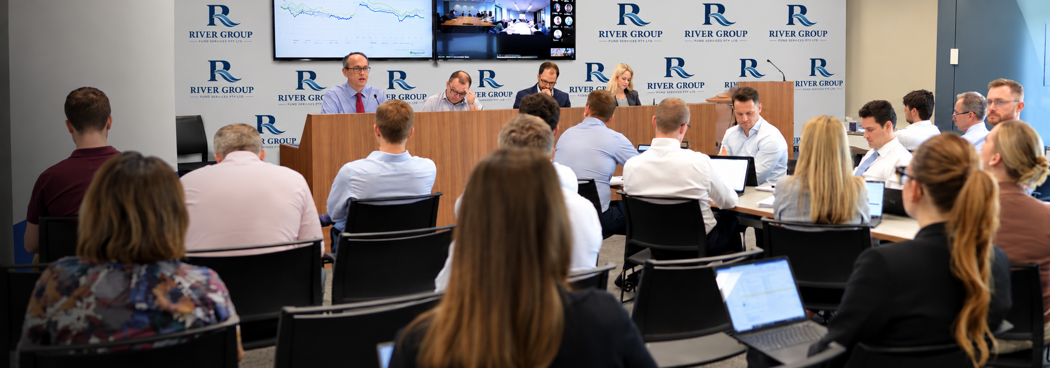 A group of people sitting in front of laptops.